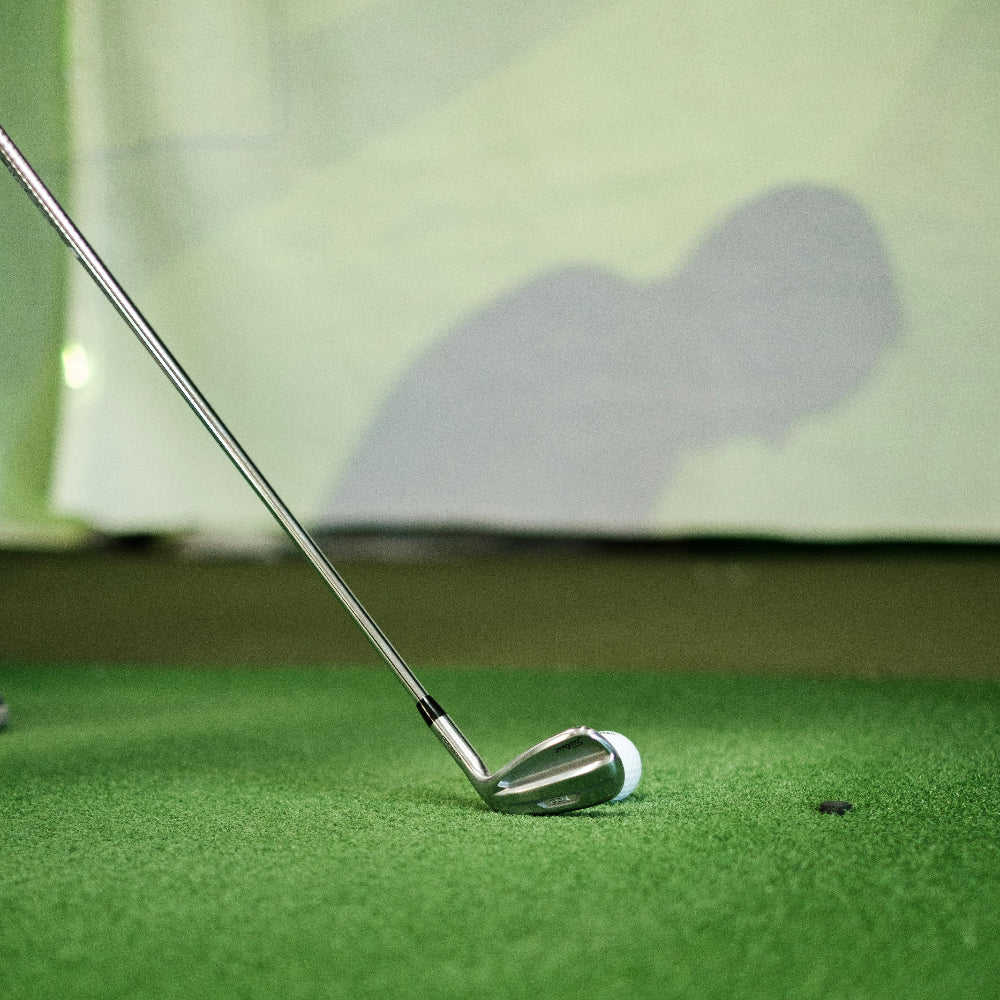 close up of golf club and ball on mat